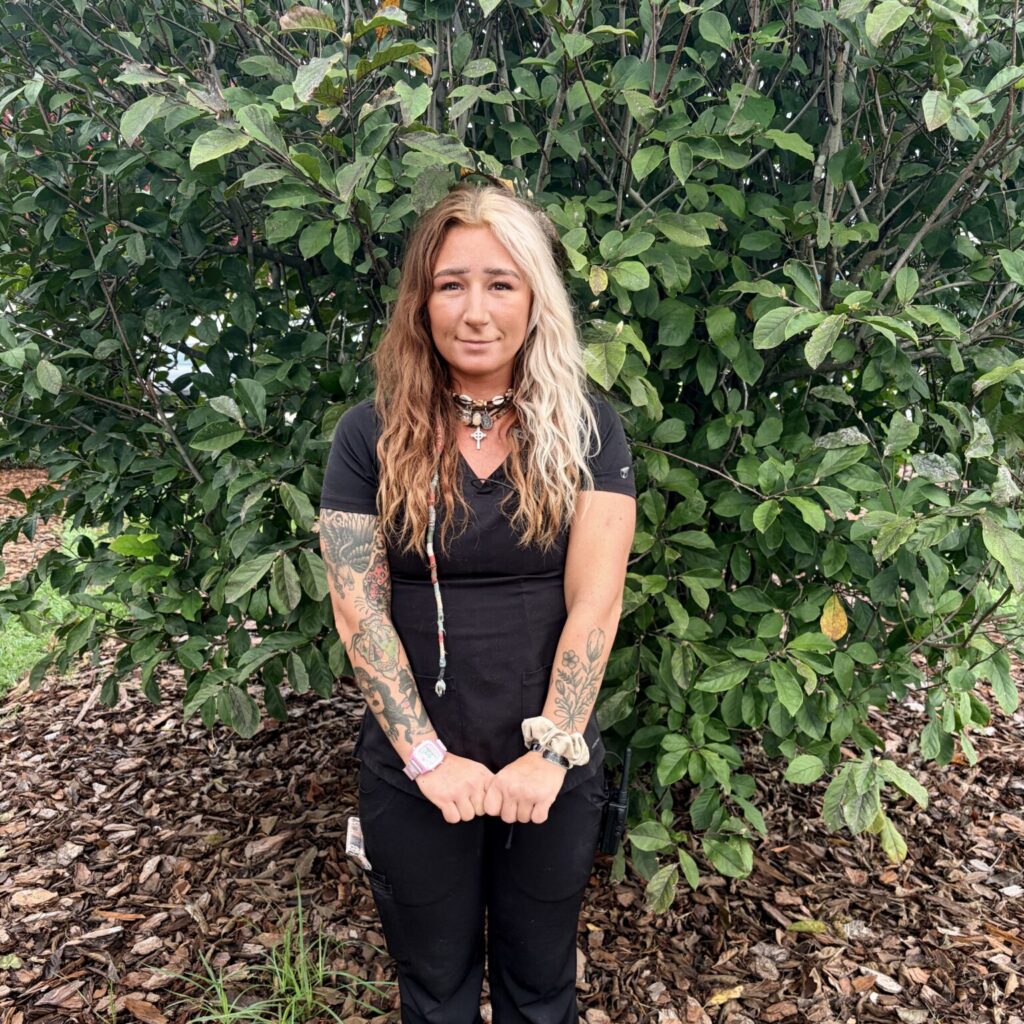 Taylor N standing outside by a tree