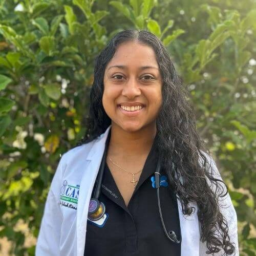 Dr. Rines smiling in front of foliage